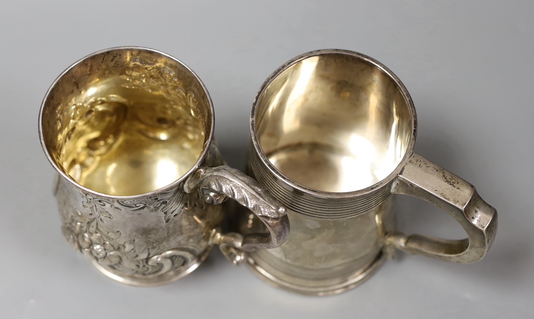A George V silver mug, with reeded bands, Elkington & Co, Birmingham, 1935, 11.5cm and a Victorian repousse silver baluster mug, Robert Harper, London, 1862, 23.8oz.